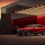 A red 2024 Cadillac LYRIQ parked at a charging station.
