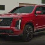 A red 2025 Cadillac Escalade-V is shown parked on a driveway.