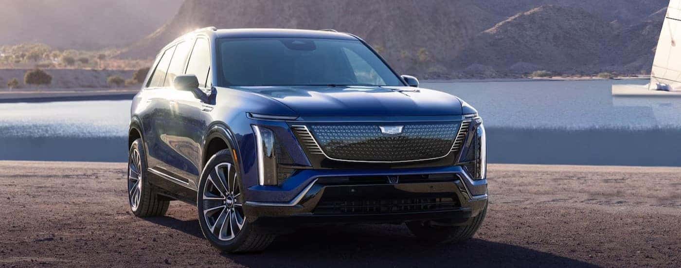 A blue 2026 Cadillac VISTIQ is shown parked near a lake.