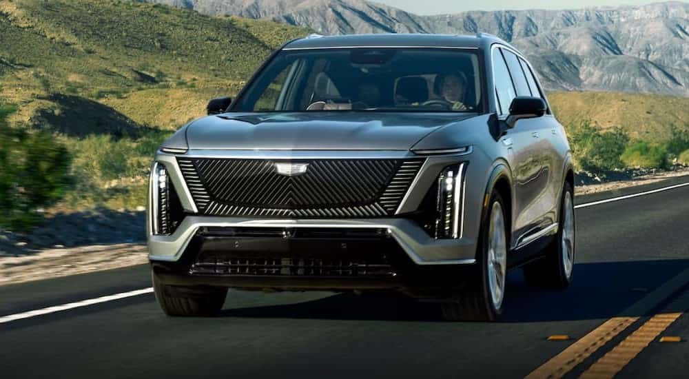 A silver 2026 Cadillac VISTIQ is shown driving on a highway.