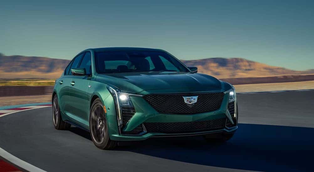 A green 2025 Cadillac CT5-V Blackwing is shown driving on a track.