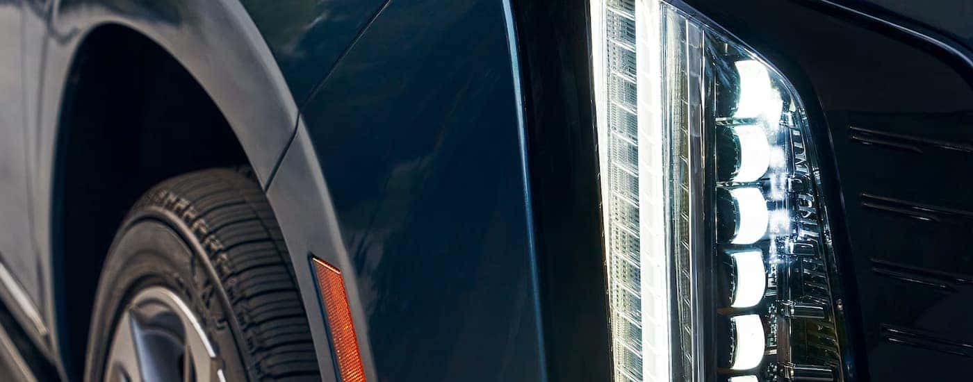 Close-up on the headlights of a blue 2025 Cadillac Escalade.