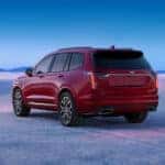 A red 2025 Cadillac XT6 is shown from the rear at an angle.