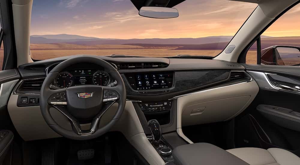 The tan interior of a 2025 Cadillac XT6 is shown from the driver's seat.