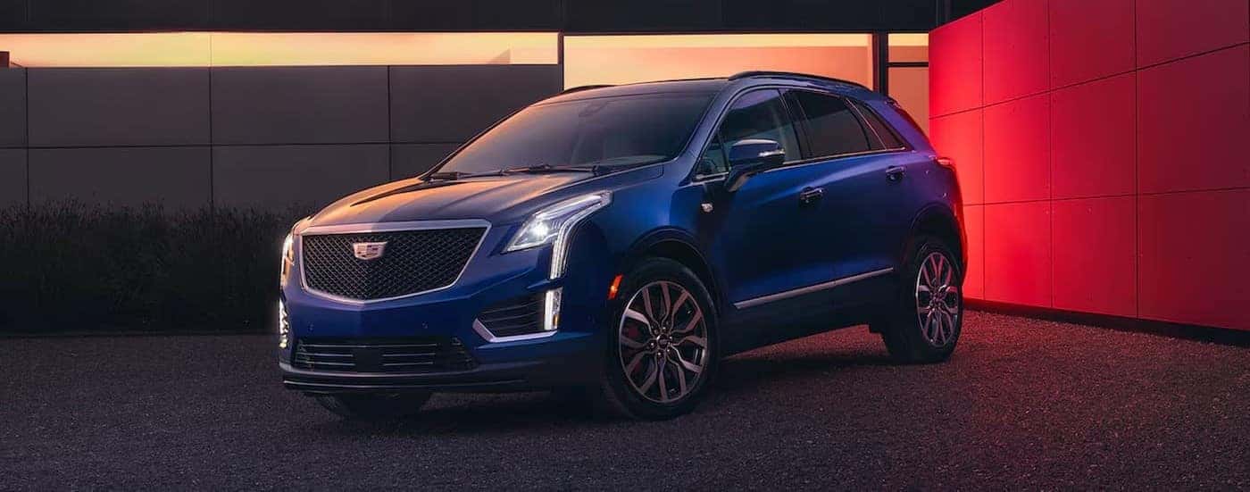 A blue 2025 Cadillac XT5 is shown parked within walls.