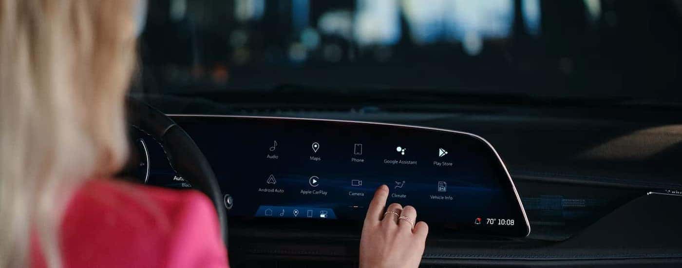 A person using an infotainment screen in a 2025 Cadillac XT4.