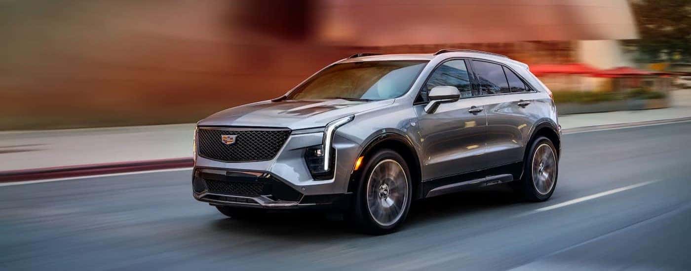 A silver 2025 Cadillac XT4 driving fast on a street.