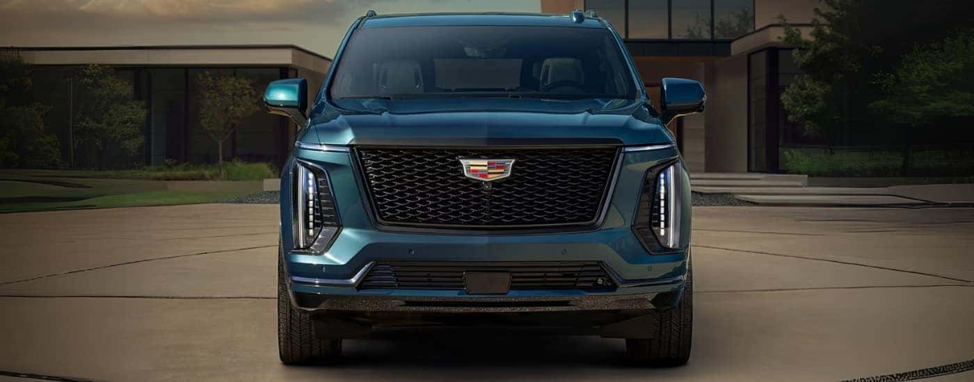 A blue 2025 Cadillac Escalade for sale near Chamblee is parked on a driveway.