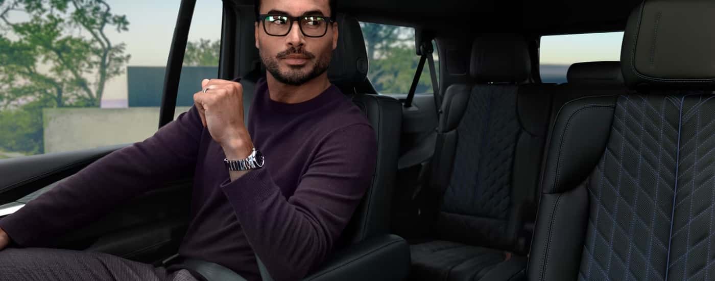 Person with glasses sitting in a 2026 Cadillac Escalade IQL.