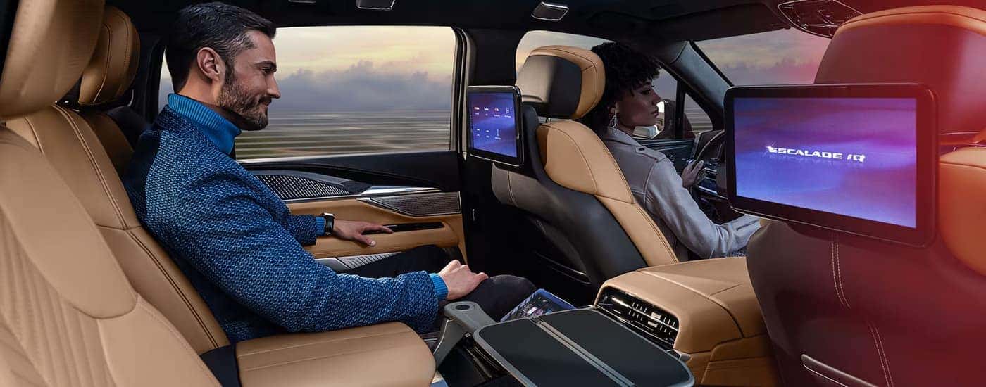 Man and woman driving in a 2025 Cadillac Escalade IQ for sale.