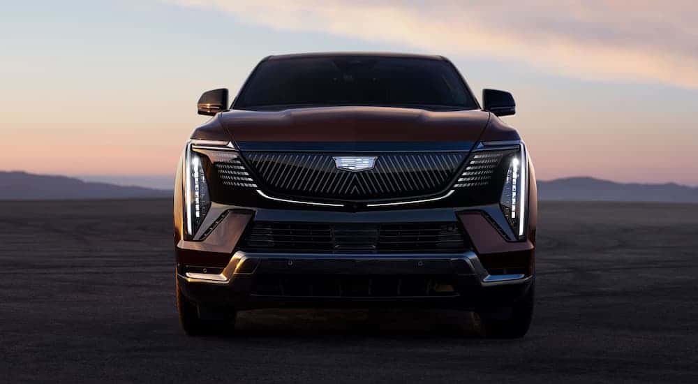 Front of a red 2025 Cadillac Escalade IQ parked in a desert.