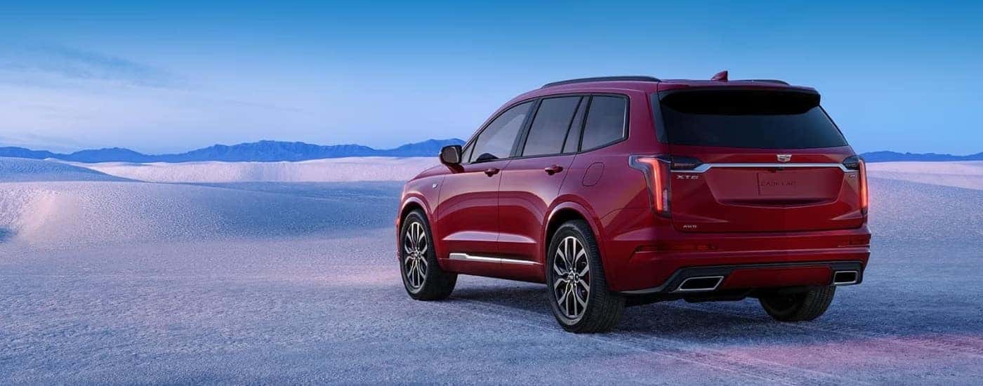 A red 2023 Cadillac XT6 parked on sand.