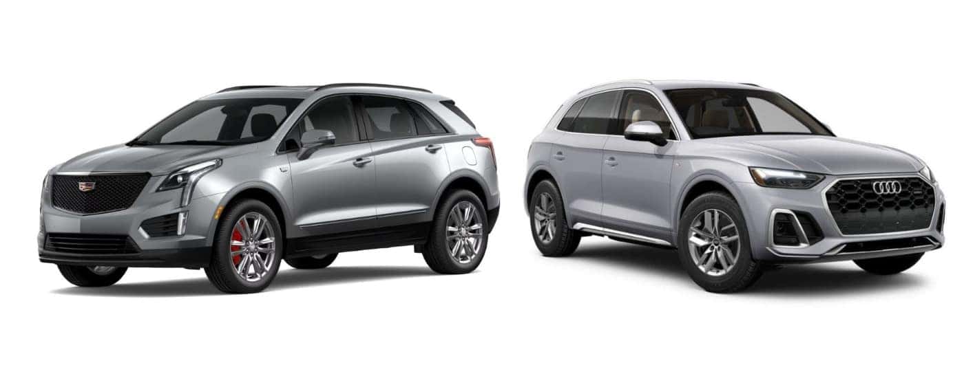 A silver 2023 Cadillac XT5 angled left and a silver 2023 Audi Q5 angled right.