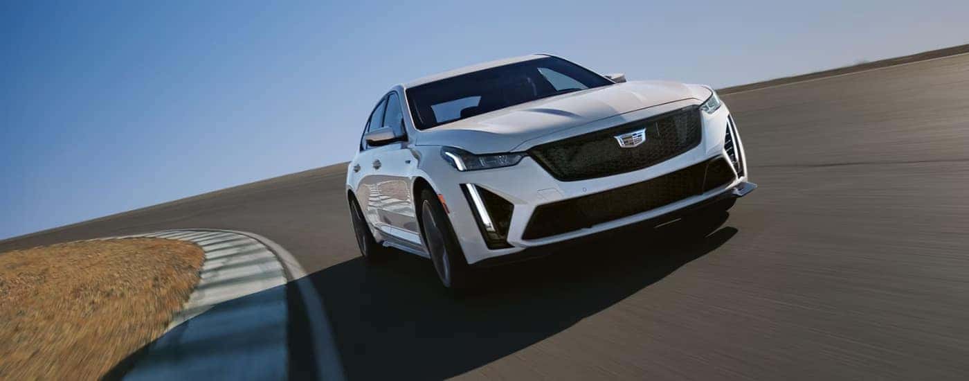 A white 2024 Cadillac CT5 driving to a Cadillac dealer near you.