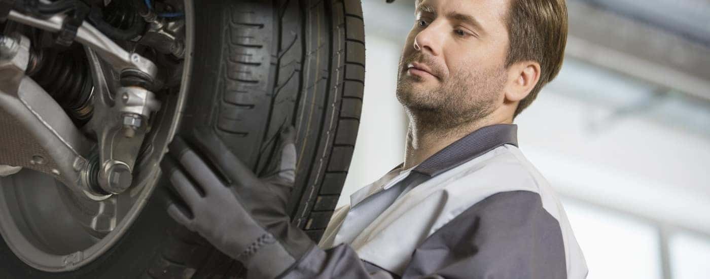 A mechanic is replacing a tire at a Cadillac service center.
