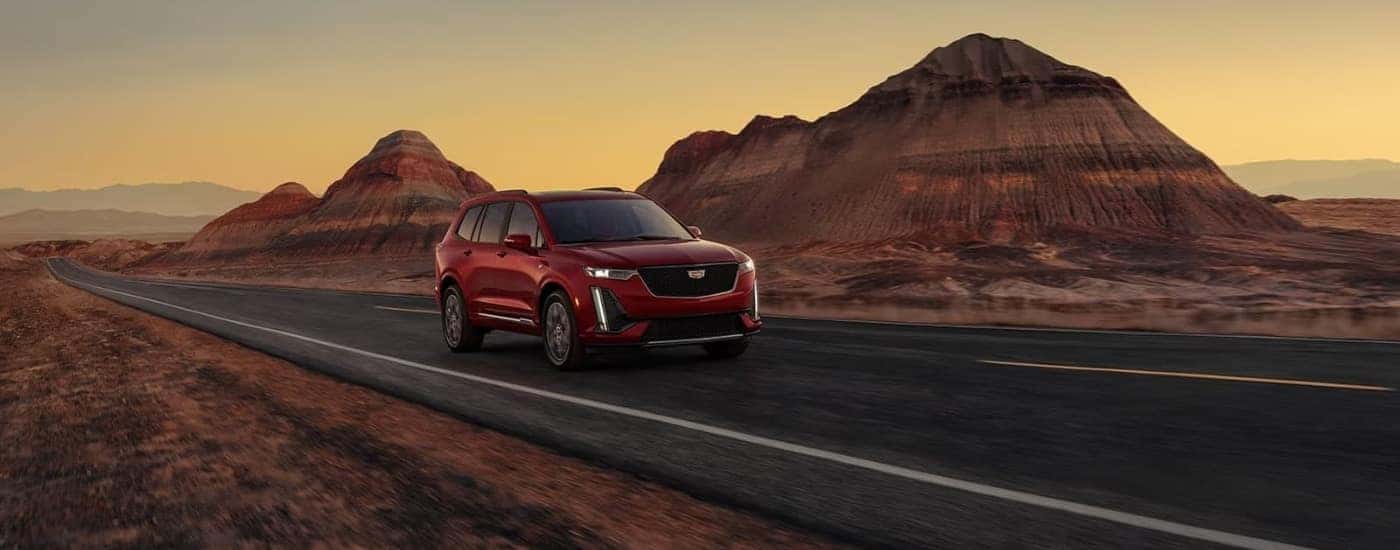 A red 2023 Cadillac XT6 for sale is shown parked off-road.