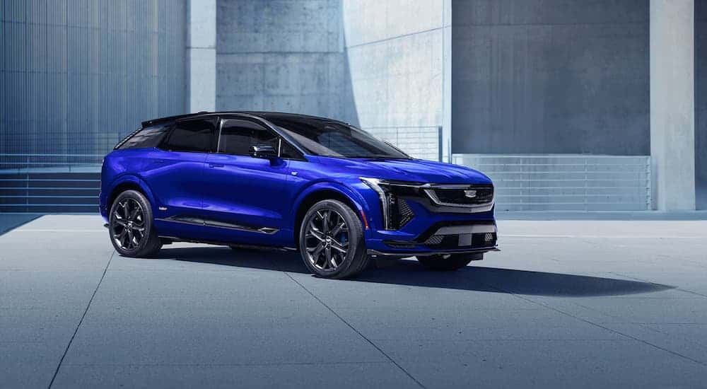 A blue 2026 Cadillac OPTIQ-V parked outside a concrete building