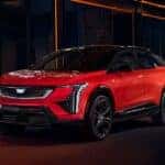 A red 2026 Cadillac OPTIQ-V parked in a city at night