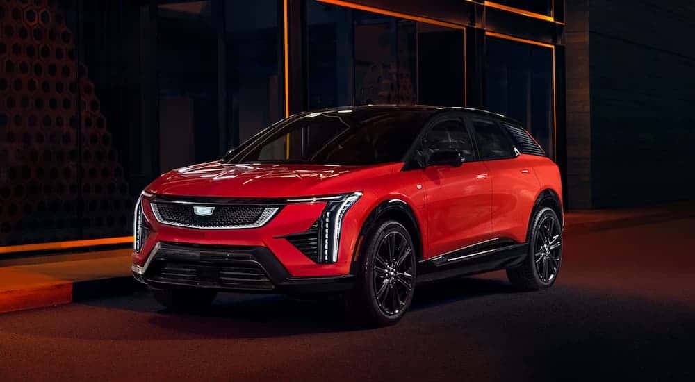 A red 2026 Cadillac OPTIQ-V parked in a city at night
