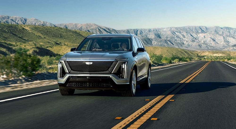 Grey 2025 Cadillac VISTIQ driving down an open road.