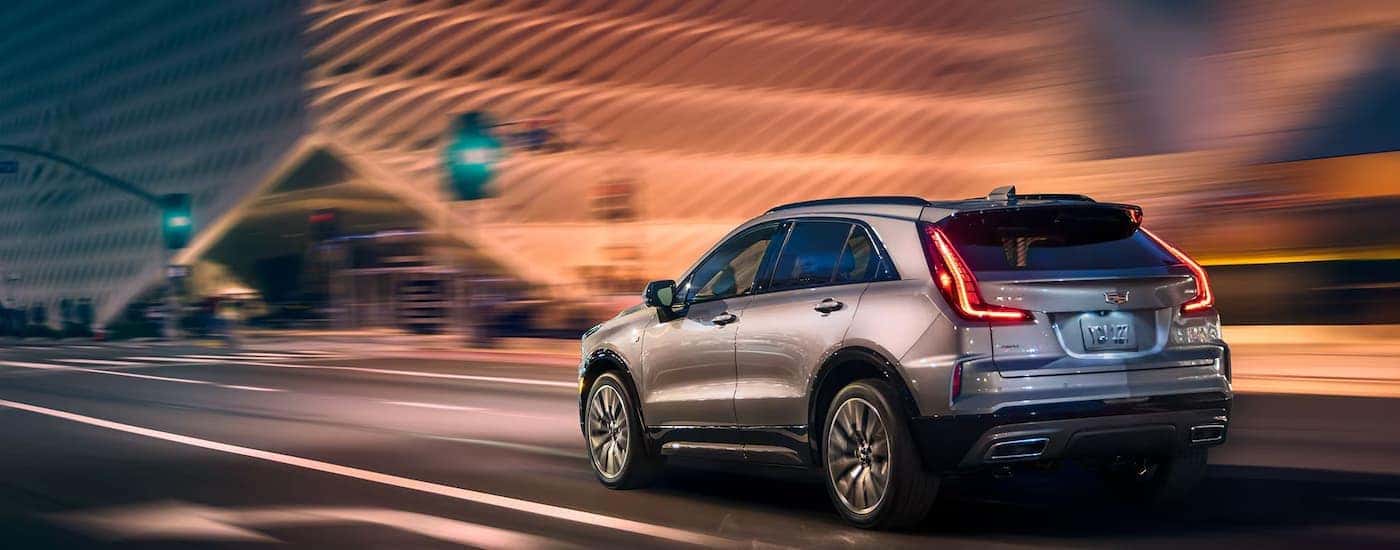 A silver 2025 Cadillac XT4 driving in a city at night