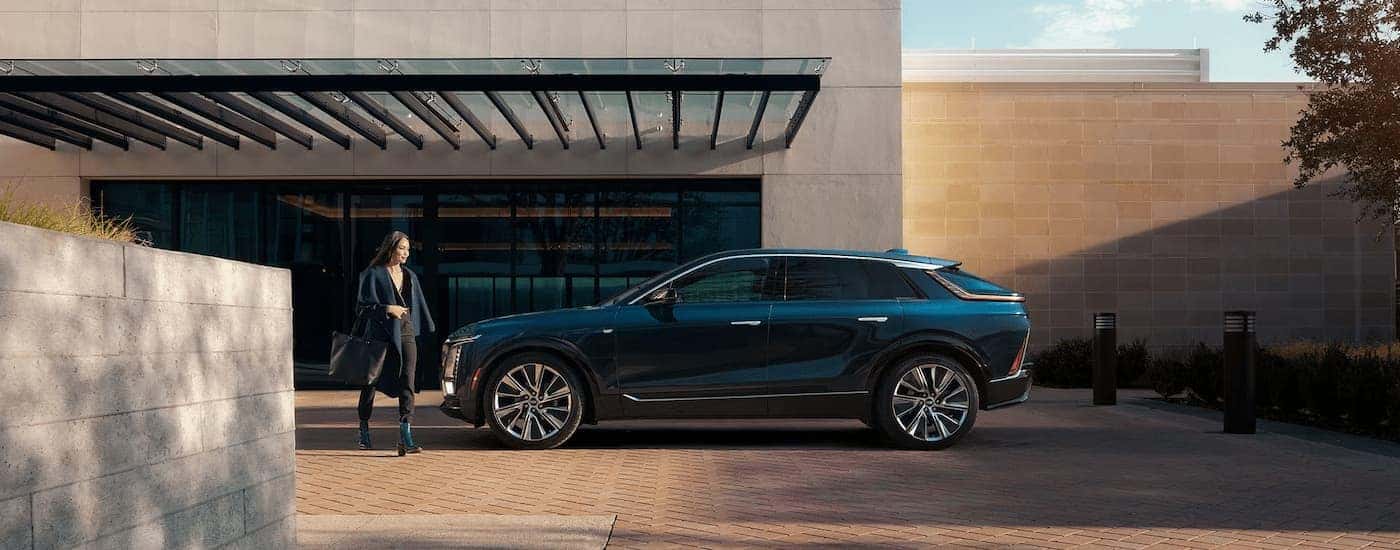 Woman walking near a blue 2026 Cadillac LYRIQ