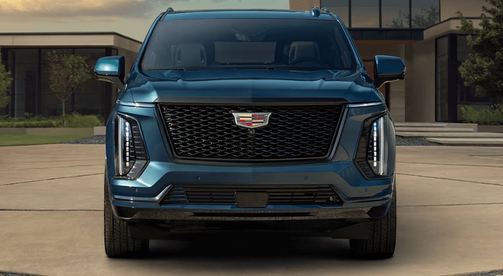 Blue 2026 Cadillac Escalade parked in front of a house head on