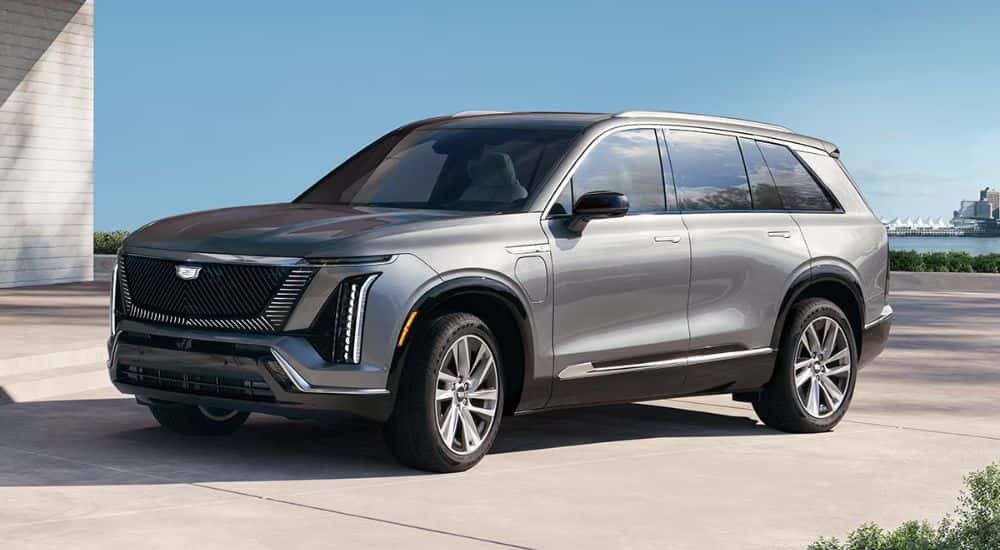Silver 2026 Cadillac VISTIQ parked in a waterfront driveway