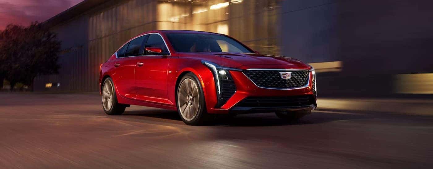 A red 2026 Cadillac CT5 driving in a city.