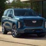 Front view of a blue 2026 Cadillac Escalade parked in a driveway.