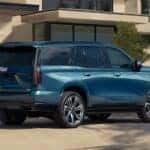 A blue 2026 Cadillac Escalade shown parked in front of a house.