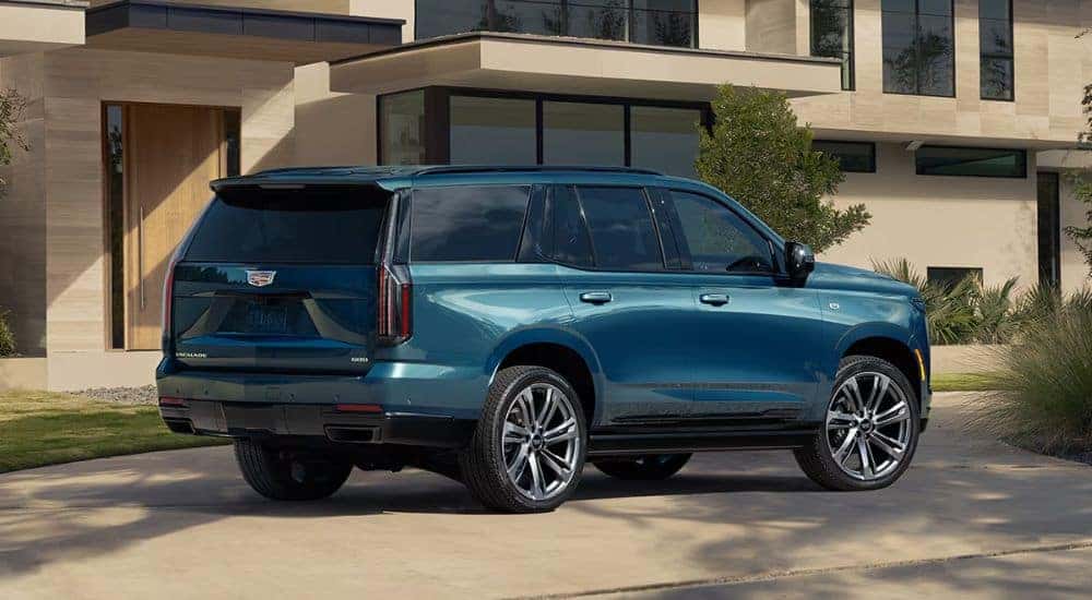 A blue 2026 Cadillac Escalade shown parked in front of a house.