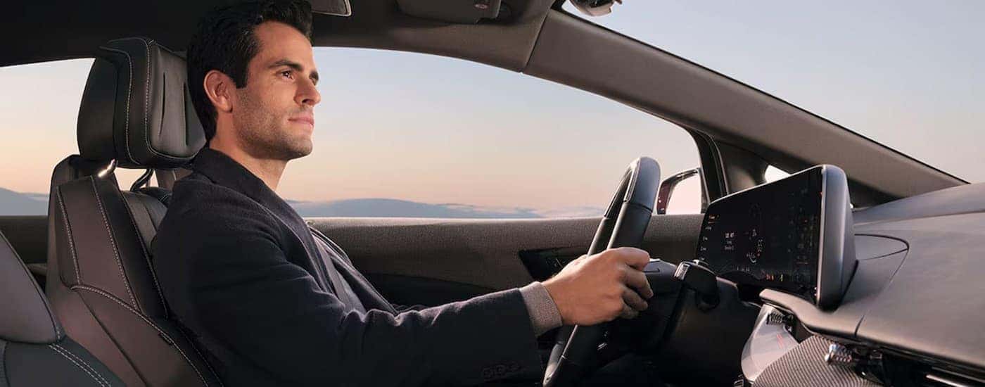 A person driving in a 2026 Cadillac OPTIQ.