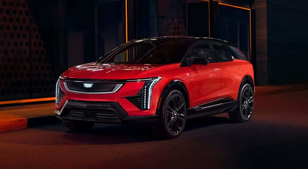 Red 2026 Cadillac OPTIQ parked on the road at night.