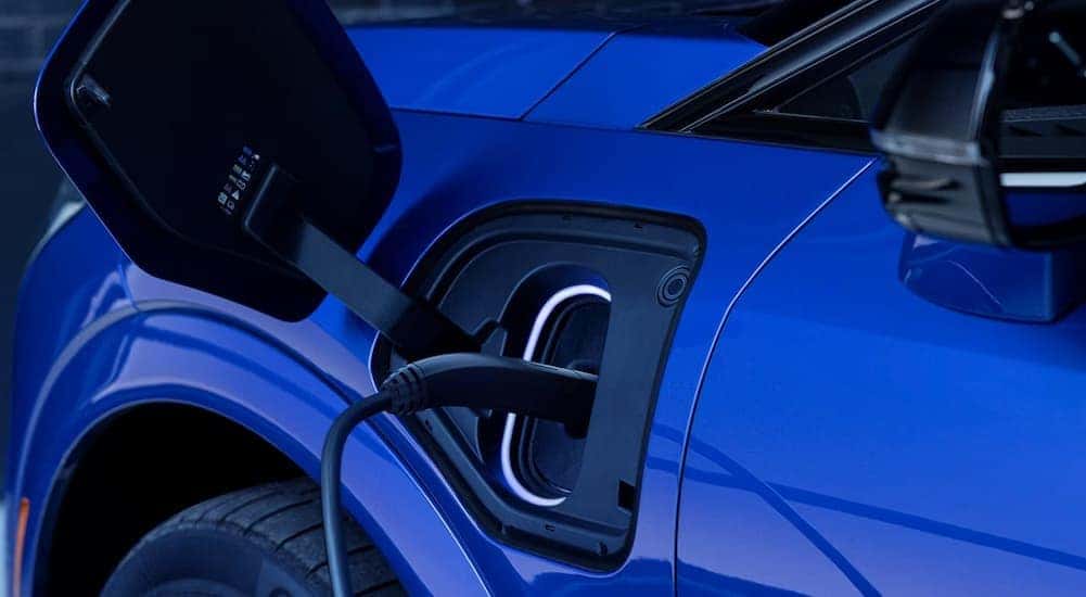 The charge port on a blue 2027 Cadillac OPTIQ.
