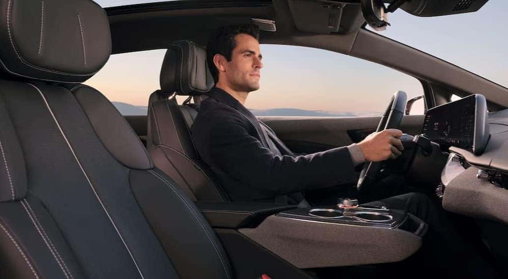 A person driving in a 2027 Cadillac OPTIQ.