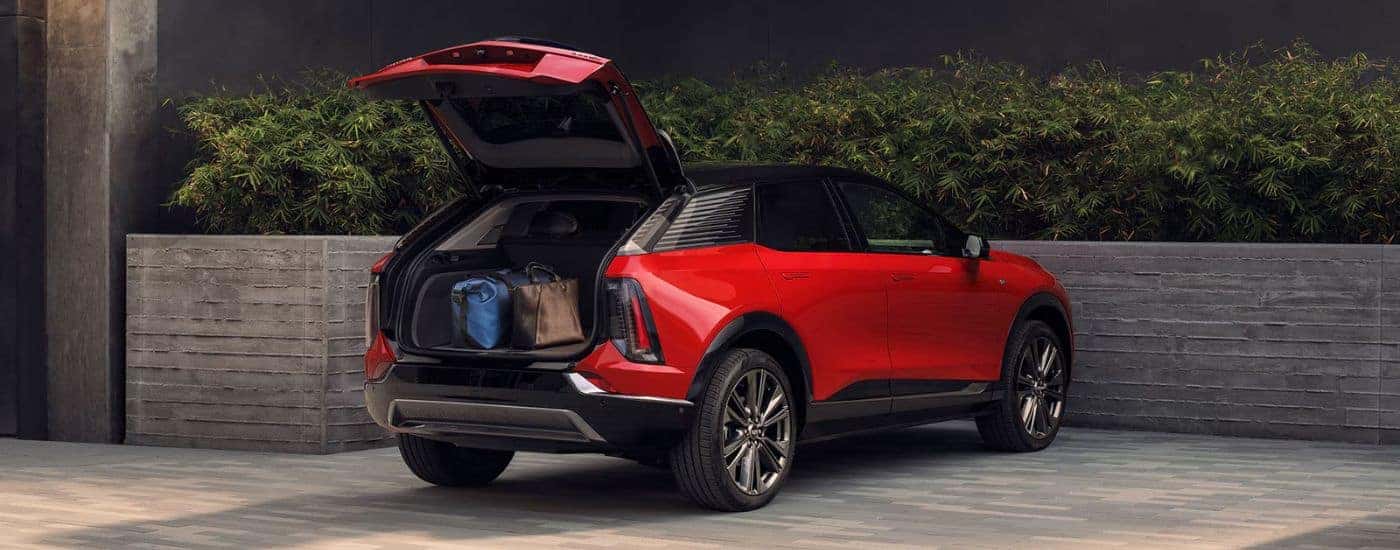 A red 2027 Cadillac OPTIQ with rear gate open.