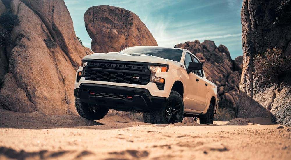 A white 2023 Chevy Silverado 1500 Z71 is shown off-roading after leaving a Chevrolet dealer.