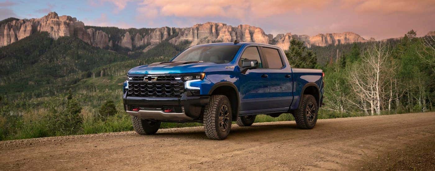 A blue 2023 Chevy Silverado 1500 ZR2 is shown driving on a trail.