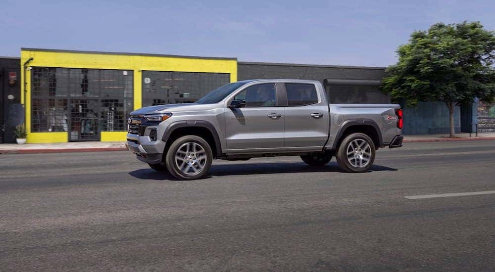 A silver 2023 Chevy Colorado Z71 is shown driving on a city street after visiting Chevrolet dealer near Atlanta, GA.