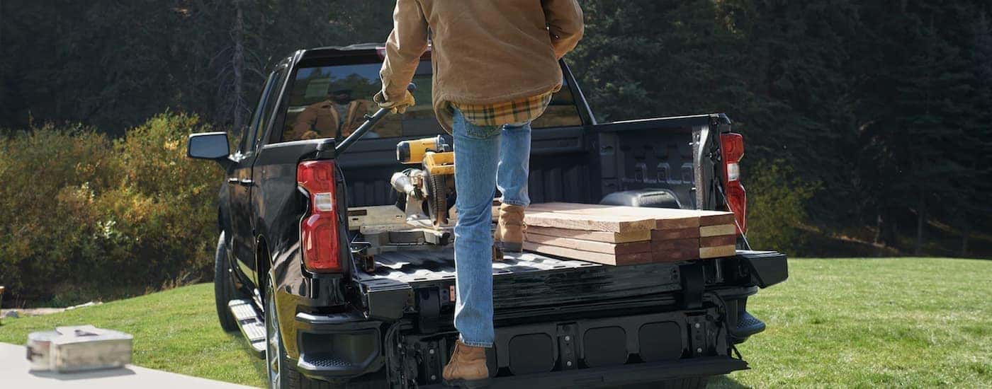 Lumber in the bed of a black 2023 Chevy Silverado 2500 HD.