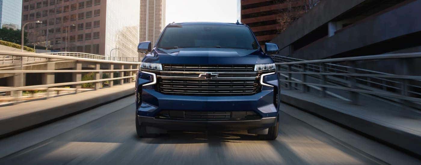 A blue 2023 Chevy Tahoe is shown from the front descending a ramp.