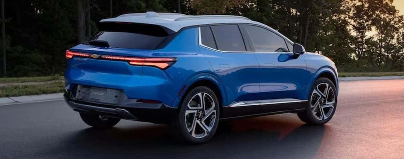 A blue 2024 Chevy Equinox EV is shown parked on a street.