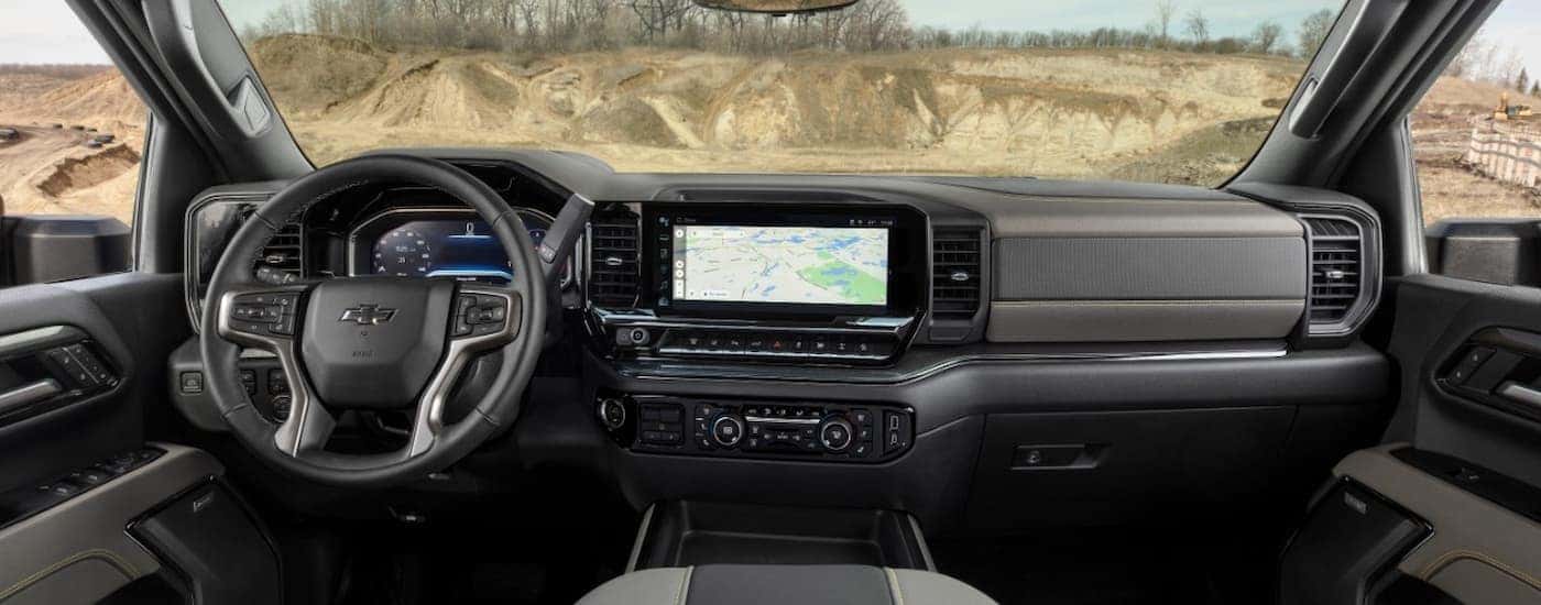 The black interior of a 2024 Chevy Silverado 2500 HD ZR2 shows the steering wheel and dashboard.