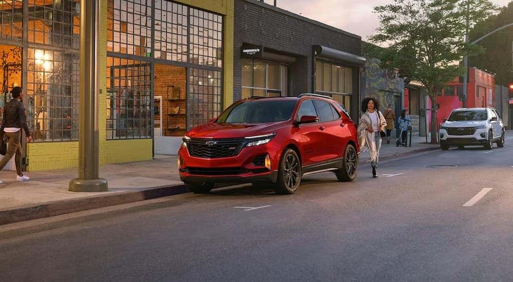 A red 2024 Chevy Equinox RS is shown parked near a Chevy Equinox dealer.