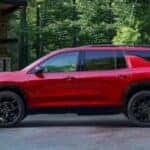 A red 2024 Chevy Traverse RS is shown parked on a driveway.