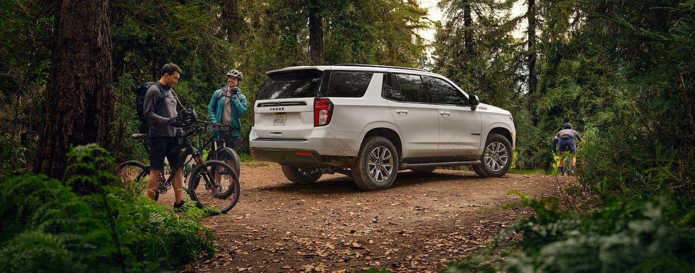 A white 2022 Chevy Tahoe Z71 is shown parked off-road in a forest.
