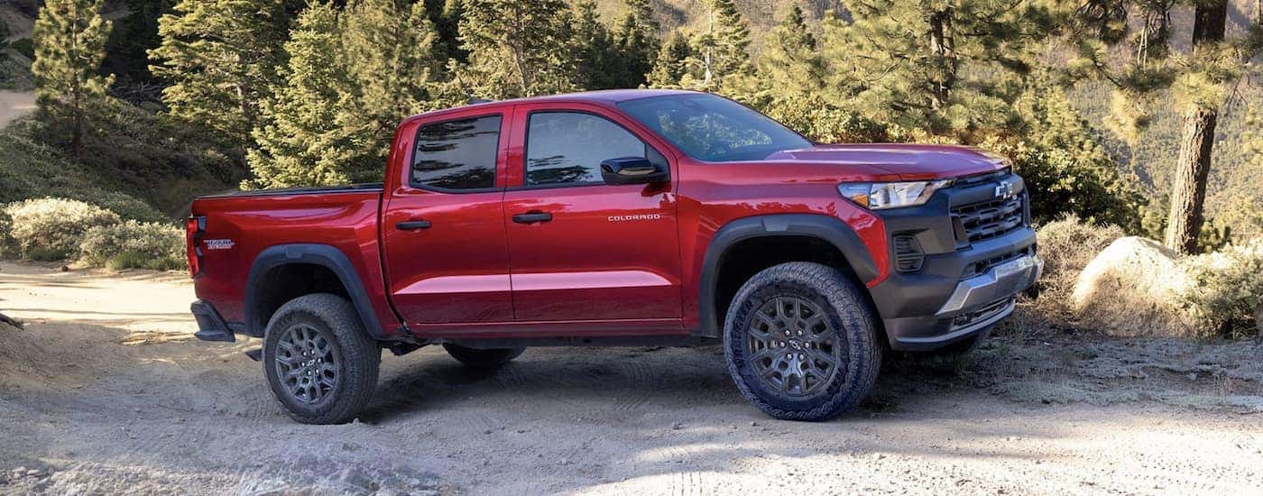 A red 2023 Chevy Colorado Trail Boss is shown parked from a side angle.