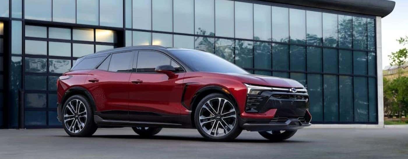 A red 2024 Chevy Blazer EV is shown parked near a garage door.