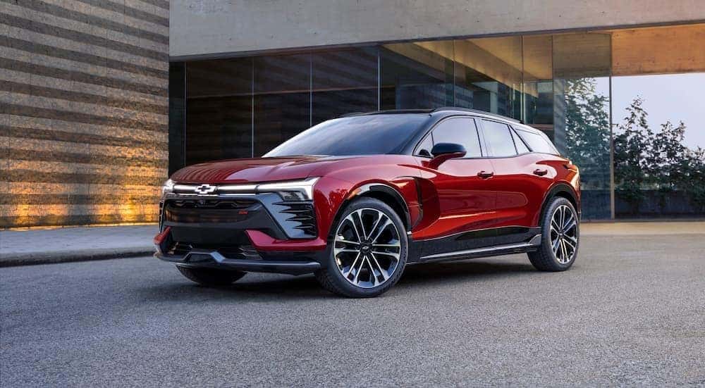 A red 2024 Chevy Blazer EV is shown parked outside a house.